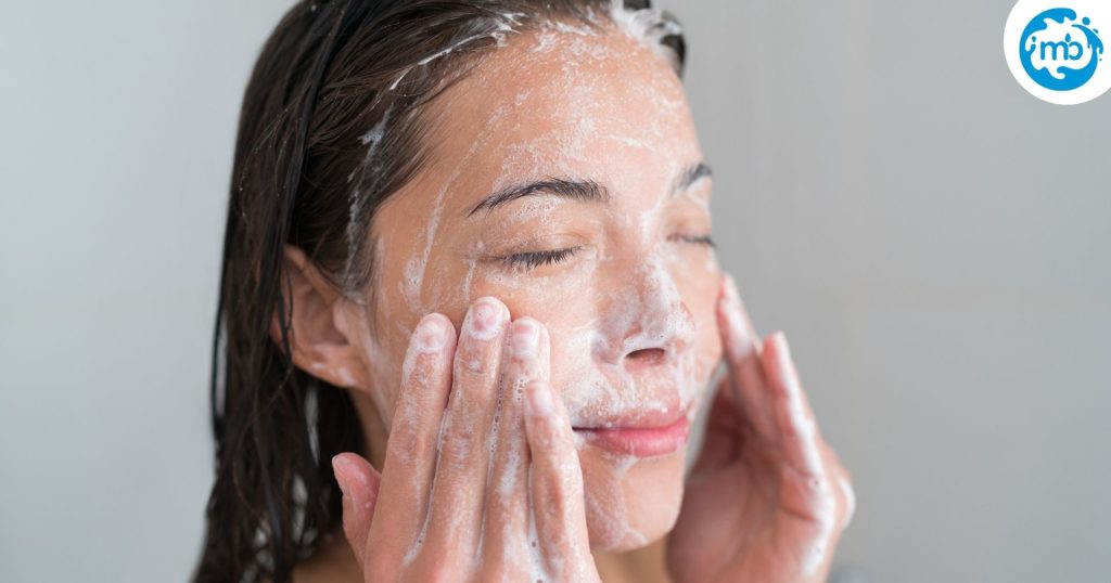 woman cleansing her face, foam on skin, massaging with fingers.