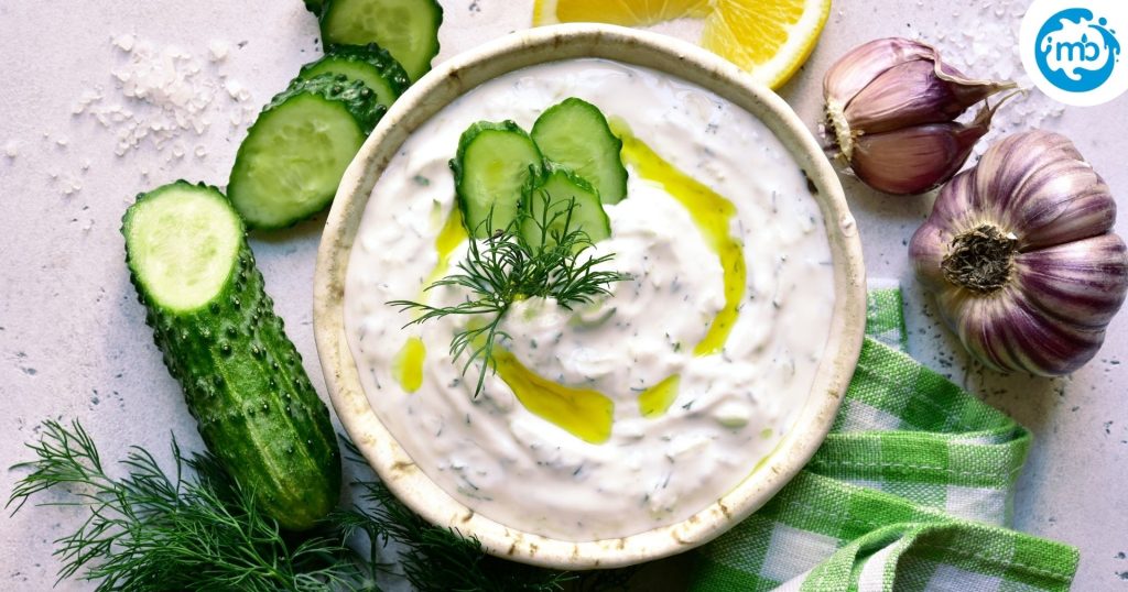  a greek yoghurt based Mediterranean/Middle Eastern dip sauce in a bowl on a white slate, solid colour background.
