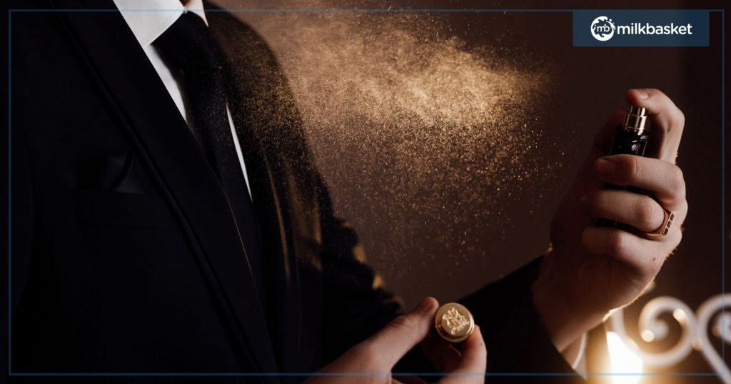 Closeup of a man in black suit spraying perfume on himself. 