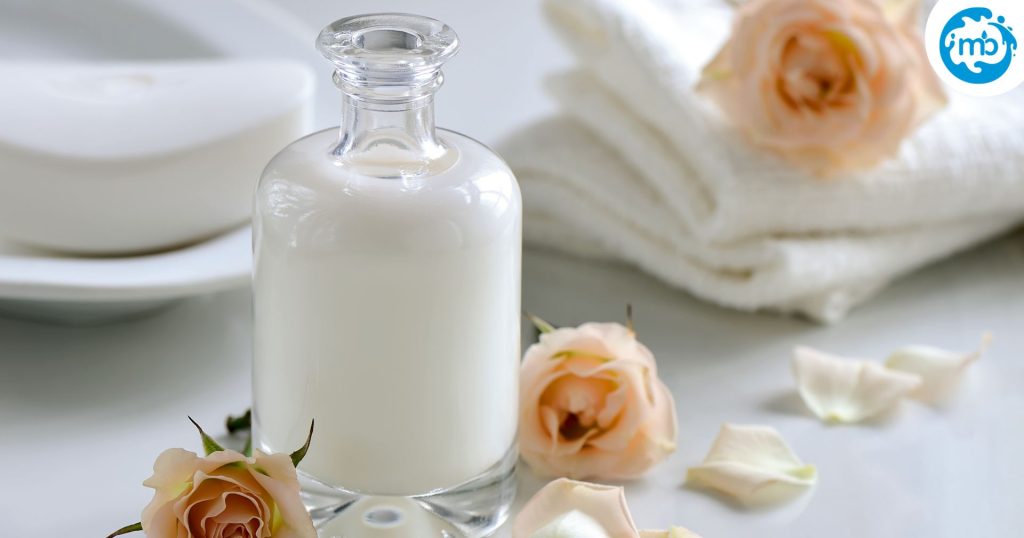 Bottle of milk, decorated with petals and towels, white background, for use in bath and beauty.