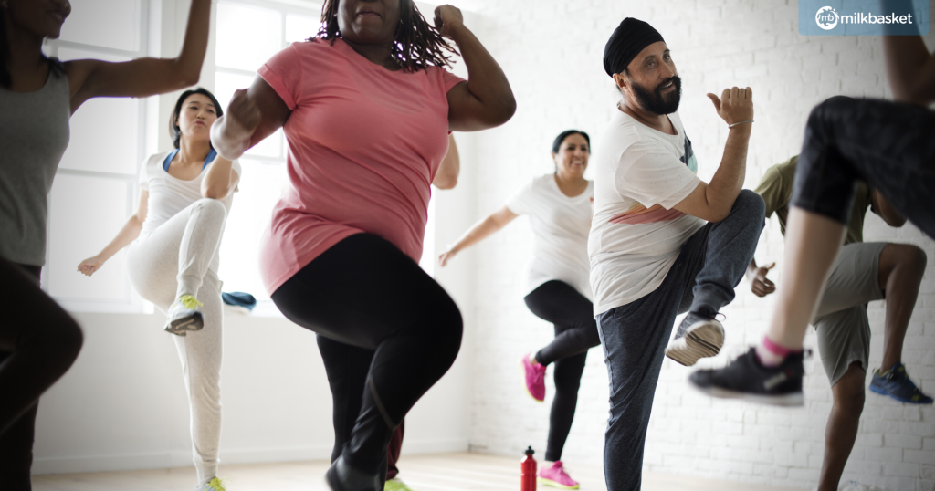 people of different ethnicities and ages in a group dance fitness class