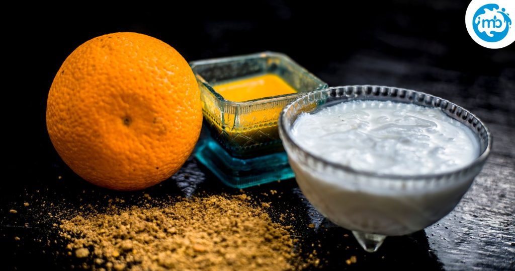 Image with fresh orange, ground turmeric, orange peel powder, milk