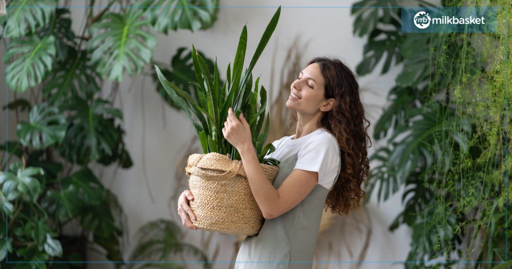 Woman feeling blissful around plants, carrying a plant pot