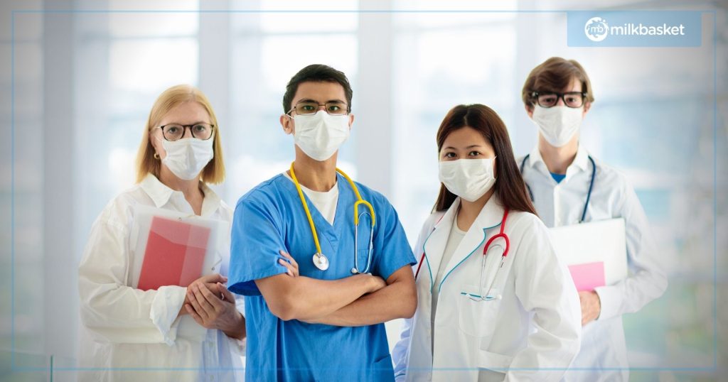 A team of doctors standing wearing all the uniforms and stethoscopes, portrait shot, blurred background 