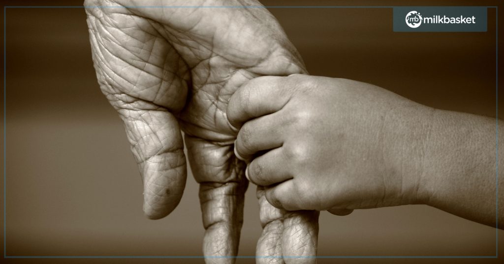 A young kid holding hand of an elder person