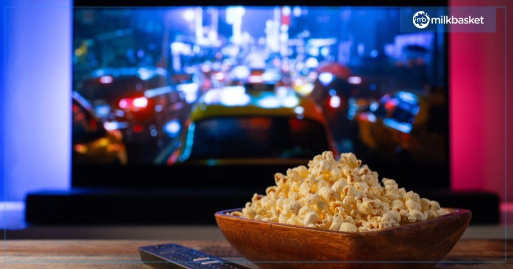 Tv Screen with popcorn and tv remote on a wooden table 