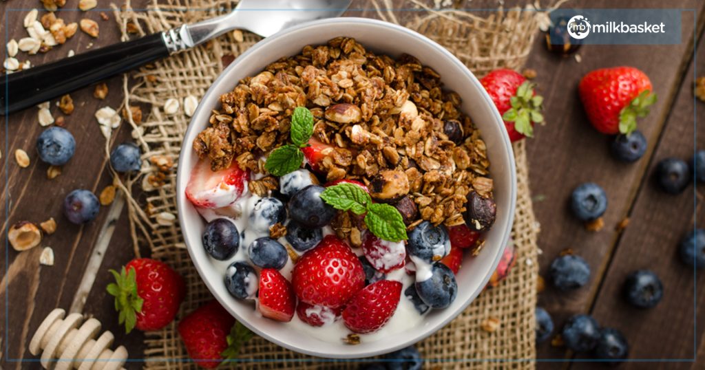 Yogurt Granola Bowl with fruits, seeds, mint leaves, nuts