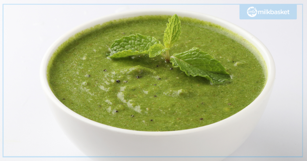 Green Chutney with mustard and mint leaves in a whie bowl