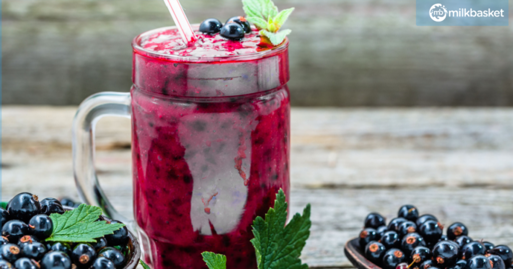 A delightful summer drink, a black currant smoothie, showcased in a glass with a straw.