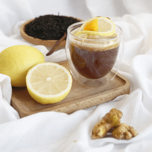 A cup of herbal tea garnished with lemon slices and fresh ginger, highlighting the refreshing and health-boosting properties of this type of tea.