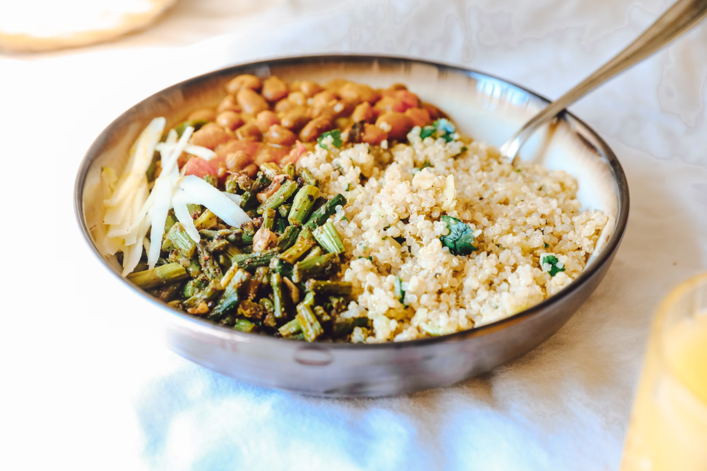 A bowl of quinoa served with vegetables and beans, presenting a nutritious and colorful grain-based meal.